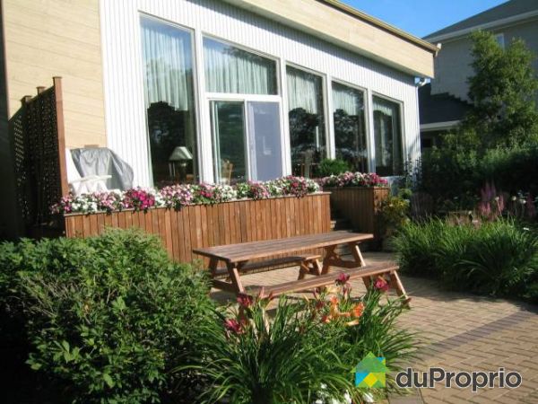 Arri&egrave;re - A l'arri&egrave;re de la maison se trouvent une galerie de bonnes dimensions ainsi que deux patios en pav&eacute; uni.
