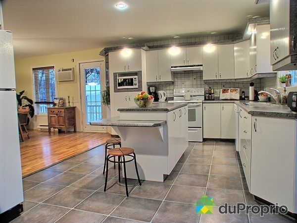 Cuisine - Beaucoup de rangement et d'espace pour cuisiner. Aussi, la porte patio est &agrave; votre droite et l'escalier du sous-sol, &agrave; votre gauche.