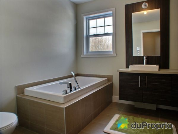 Salle de bain - Maison mod&egrave;le &agrave; vendre: Vanit&eacute; suspendue, miroir, pharmacie, Douche 36x36, bain podium, et toilette double d&eacute;bit.