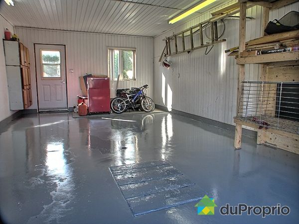 Garage - &Agrave; partir du garage acc&egrave;s direct &agrave; l'atelier sous le garage et &agrave; l'entr&eacute;e  menant au sous-sol. Une trappe dans le plancher du garage permet de rendre le bois dans l'atelier. 