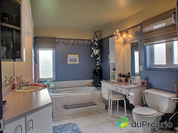 Salle de bain - Spacieuse salle de bain  avec une grande baignoire (66X36) sur podium et douche s&eacute;par&eacute; (36X36). Panier &agrave; linge int&eacute;gr&eacute; aux armoires et coiffeuse.  Plancher en c&eacute;ramique compl&egrave;te le tout.