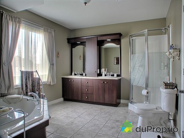 Salle de bain - Grande salle de bain &agrave; l'&eacute;tage communiquant avec la chambre des ma&icirc;tres et &eacute;quip&eacute;e d'un bain th&eacute;rapeutique et d'un grande vanit&eacute; &agrave; deux lavabos.